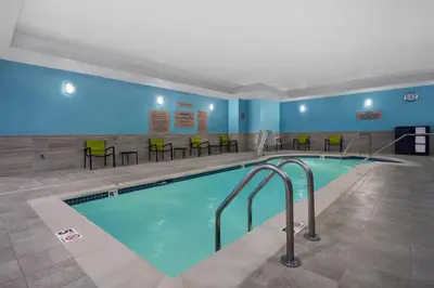 a pool in a hotel room with chairs and tables at SpringHill Suites by Marriott Hartford Cromwell in Cromwell