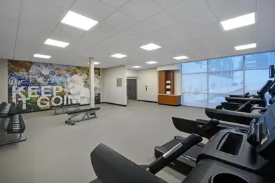 a gym with rows of exercise equipment and a large screen at SpringHill Suites by Marriott Hartford Cromwell in Cromwell