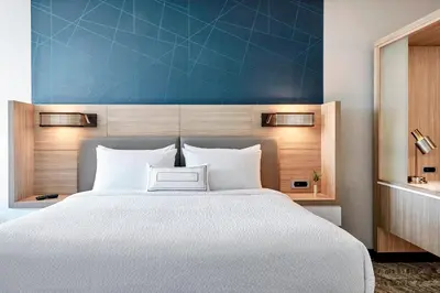 a bedroom with a large bed with a blue wall at SpringHill Suites by Marriott Hartford Cromwell in Cromwell