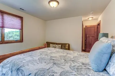 a bedroom with a bed and a window at Peaceful Mountian Oasis Firepit, Hot Tub, Sauna! in Vernon Township
