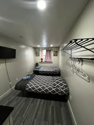 a room with two beds and a tv in it at 31 Street Broadway Hotel in New York