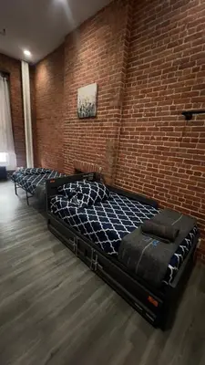 a bed in a room with a brick wall at 31 Street Broadway Hotel in New York
