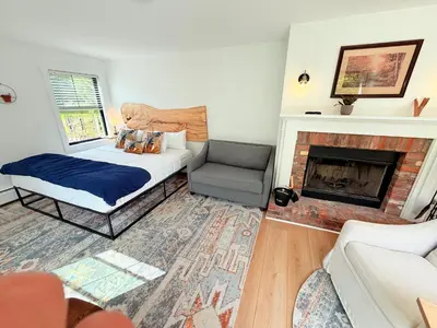a bedroom with a bed and a chair and a fireplace at Farm Road Estate in West Dover