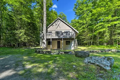 a house in the middle of a field with trees at Sleek Cabin with Deck, 8 Miles to Mount Snow and Hikes in Wilmington