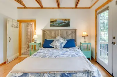 a bedroom with a large bed and two tables at East Otis Vacation Rental with Private Deck and BBQ! in East Otis