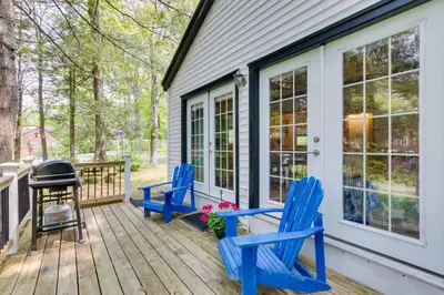 two blue chairs on a deck with a grill at East Otis Vacation Rental with Private Deck and BBQ! in East Otis