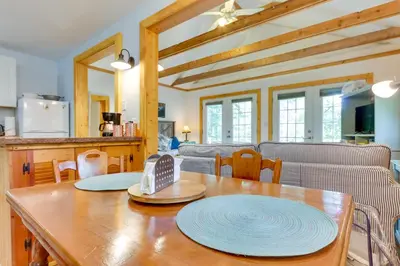 a kitchen and living room with a table and a couch at East Otis Vacation Rental with Private Deck and BBQ! in East Otis