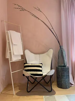 a chair in a room with a vase and a shelf at The Trail in Adams - Berkshires' Art Hotel in Adams