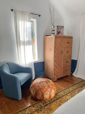 a living room with a chair and a ottoman at The Trail in Adams - Berkshires' Art Hotel in Adams