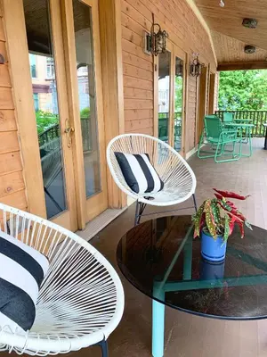 two white chairs and a table on a porch at The Trail in Adams - Berkshires' Art Hotel in Adams
