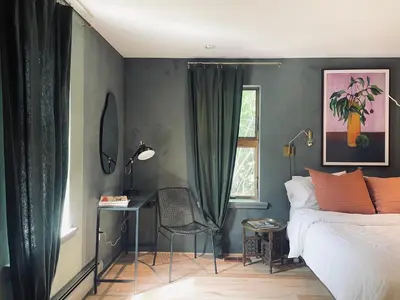a bedroom with a bed and a chair and a window at The Trail in Adams - Berkshires' Art Hotel in Adams