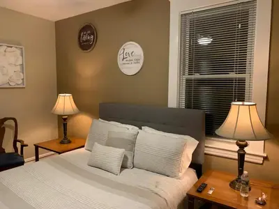 a bedroom with a bed with two lamps and a window at Historical Neighborhood Home in New Rochelle