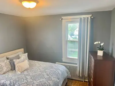 a bedroom with a bed and a window and a dresser at Historical Neighborhood Home in New Rochelle