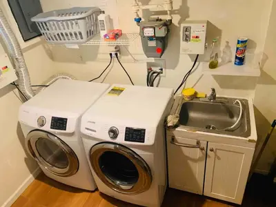 a washing machine and a sink in a room at Historical Neighborhood Home in New Rochelle