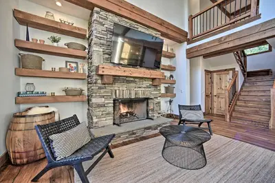 a living room with two chairs and a fireplace at Luxury Home with Deck Explore the Catskill Mtns! in Windham