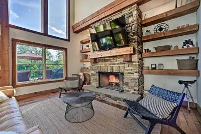 a living room with a stone fireplace at Luxury Home with Deck Explore the Catskill Mtns! in Windham