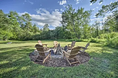 a group of chairs sitting around a fire pit at Luxury Home with Deck Explore the Catskill Mtns! in Windham