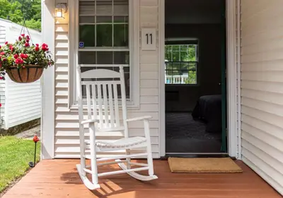 a white rocking chair on the front porch of a house at Arcady Mountain Motor Lodge in Sunderland