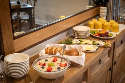 a breakfast buffet with bread and fruit on a table at Arcady Mountain Motor Lodge in Sunderland