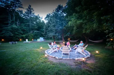 a group of people sitting around a fire in a yard at Arcady Mountain Motor Lodge in Sunderland