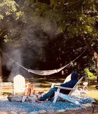 a person sitting in a chair next to a fire at Arcady Mountain Motor Lodge in Sunderland
