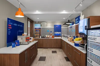 a large kitchen with wooden cabinets and counters at Holiday Inn Express & Suites Woodside LaGuardia Airport in Queens