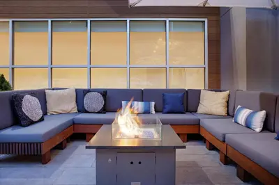 a living room with couches and a fire pit at Element New York Wood Ridge in Wood-Ridge