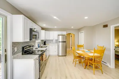 a kitchen with white cabinets and a table and chairs at Relaxing Catskills Apt Less Than 3 Mi to Windham Mountain! in Windham