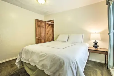 a bedroom with a bed and a table with a lamp at Spacious Apt with Yard 3 Mi to Windham Mountain in Windham