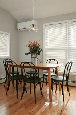 a dining room table with chairs and a vase of flowers at Holly Lodge - Ski Windham Hunter Catskills in Prattsville