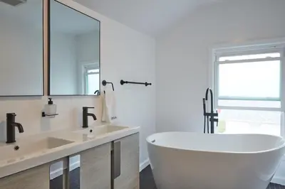 a white bathroom with a tub and a sink at Holly Lodge - Ski Windham Hunter Catskills in Prattsville