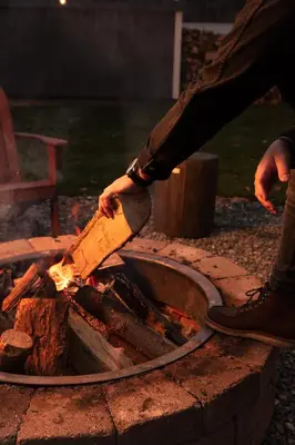 a person holding a large axe over a fire at Holly Lodge - Ski Windham Hunter Catskills in Prattsville