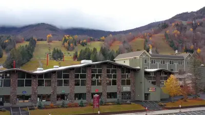 a large building with a mountain in the background at Holly Lodge - Ski Windham Hunter Catskills in Prattsville