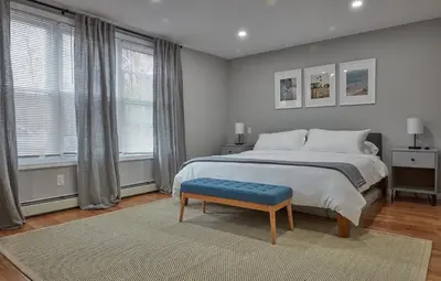 a bedroom with a large bed and a blue stool at Holly Lodge - Ski Windham Hunter Catskills in Prattsville