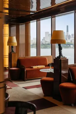 a living room with a couch and a table with lamps at Casa Cipriani New York in New York