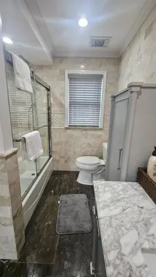 a bathroom with a toilet and a shower and a sink at Luxury Hotel-Style Room in Queens, New York in Bayside