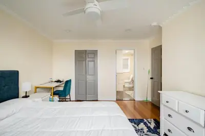 a bedroom with a large white bed and a desk at Luxury Hotel-Style Room in Queens, New York in Bayside