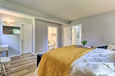 a bedroom with a large bed and a bathroom at Hot Tub, Fire Pit and Resort Perks Tobyhanna Home! in Tobyhanna