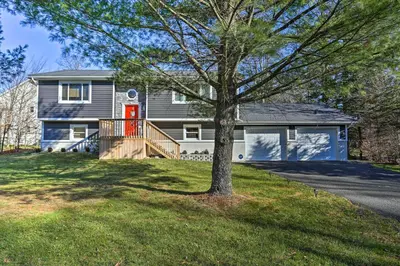 a house with a red door and a tree at Hot Tub, Fire Pit and Resort Perks Tobyhanna Home! in Tobyhanna