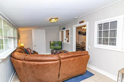 a living room with a large brown leather couch at Camelback cottage - on ONE ACRE & near local attractions in Tannersville