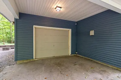 a garage with a garage door in a blue wall at Camelback Rd Rancher- On ONE ACRE & near attractions in Tannersville