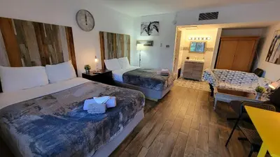 a hotel room with two beds and a living room at Sussex Motel in Wantage