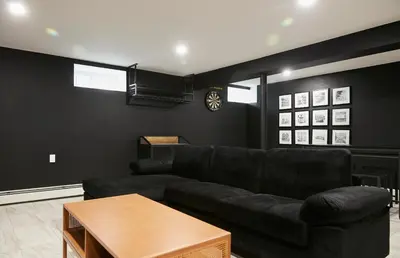 a living room with a black couch and a table at Chateau Lodge - Ski Shandaken, Hunter, Catskills, Windham, Belleayre in Shandaken