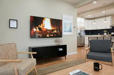a living room with a couch and a fire on the wall at Chateau Lodge - Ski Shandaken, Hunter, Catskills, Windham, Belleayre in Shandaken