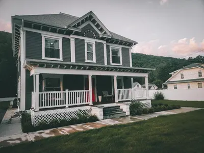 a house with a porch and a white fence at Chateau Lodge - Ski Shandaken, Hunter, Catskills, Windham, Belleayre in Shandaken