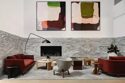 a living room with red furniture and a fireplace at Arlo Midtown in New York