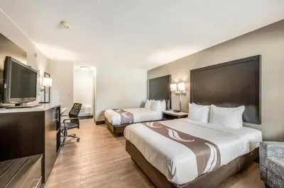 a hotel room with two beds and a flat screen tv at Quality Inn Poughkeepsie in Poughkeepsie