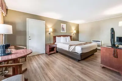 a hotel room with a bed and a flat screen tv at Rodeway Inn Poughkeepsie in Poughkeepsie