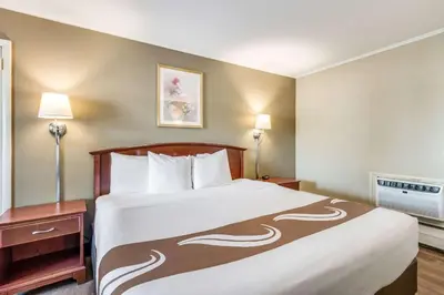a large bed in a hotel room with two lamps at Rodeway Inn Poughkeepsie in Poughkeepsie