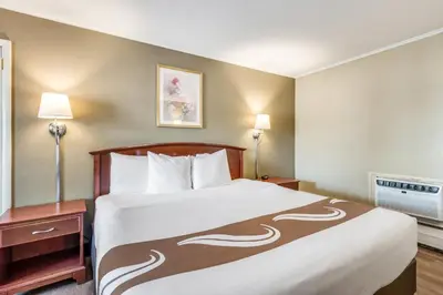 a large bed in a hotel room with two lamps at Rodeway Inn Poughkeepsie in Poughkeepsie